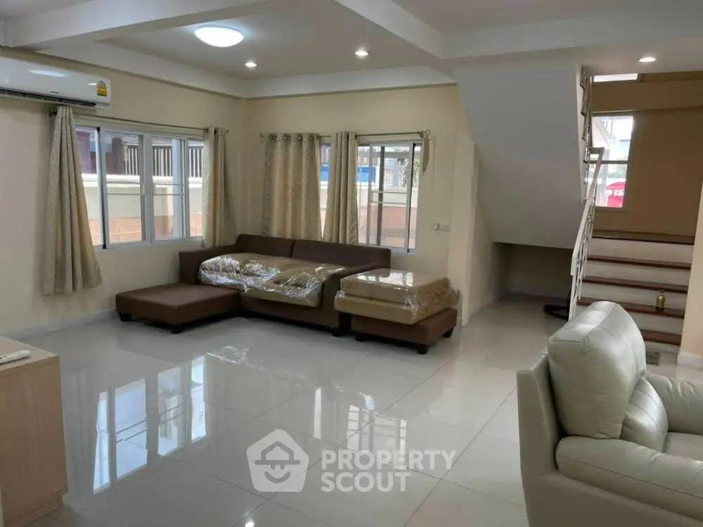 Spacious living room with modern furniture and natural light, perfect for family gatherings.