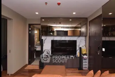 Modern living room with sleek design and large TV, featuring elegant wooden flooring.