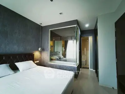 Modern bedroom with stylish decor and ensuite bathroom in a contemporary apartment.
