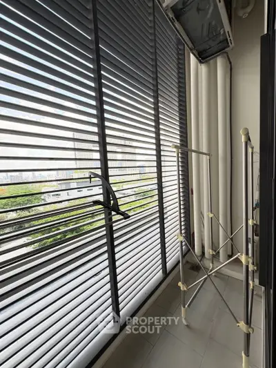 Modern balcony with sleek blinds and drying rack overlooking cityscape