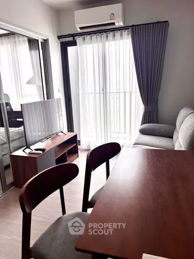 Modern living room with sleek furniture and large window for natural light.