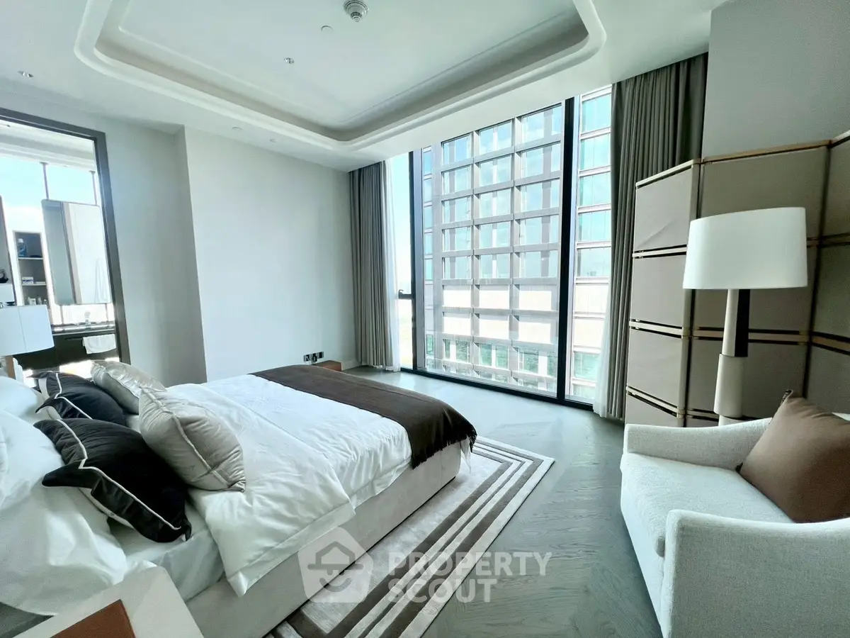 Luxurious modern bedroom with floor-to-ceiling windows and elegant decor in a high-rise apartment.