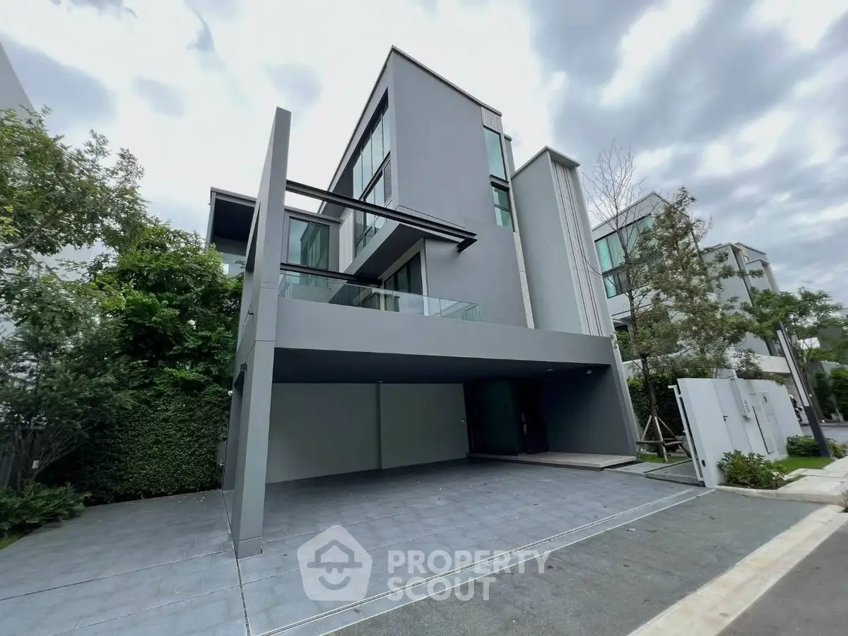 Modern three-story building with sleek design and spacious driveway