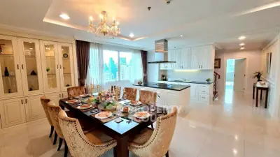 Luxurious open-layout dining and kitchen area with elegant chandelier and city view.