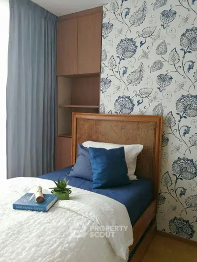 Charming bedroom with floral accent wall and cozy bedding in modern apartment.