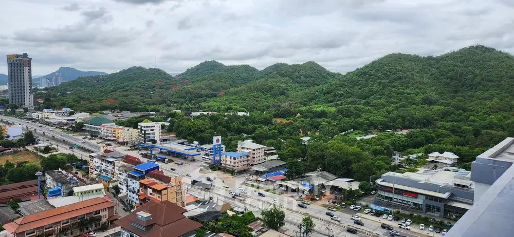 Scenic aerial view of urban landscape with lush green hills and modern buildings