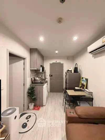 Cozy apartment interior with modern kitchen and dining area, featuring sleek appliances and stylish decor.