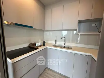 Modern kitchen with sleek cabinetry and built-in appliances in a compact layout
