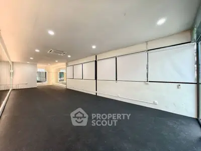 Spacious interior room with large windows and modern lighting, ideal for versatile use.