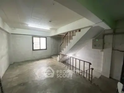 Spacious unfinished basement with concrete floors and staircase, ideal for storage or renovation.