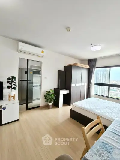Modern bedroom with large window and city view, featuring sleek furniture and natural light.