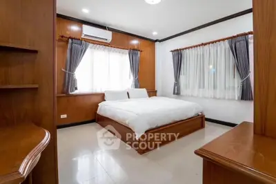 Spacious bedroom with wooden accents and large windows for natural light