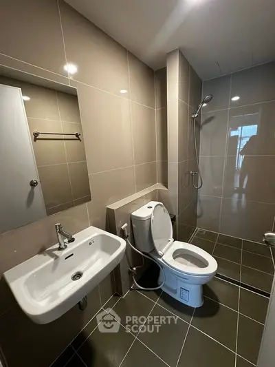 Modern bathroom with sleek fixtures and tiled walls in a contemporary apartment.