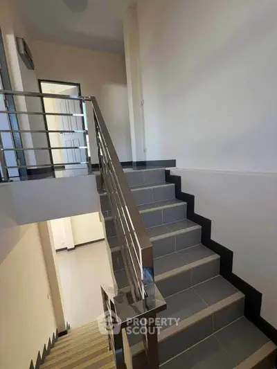 Modern staircase with sleek metal railing in a contemporary home interior.