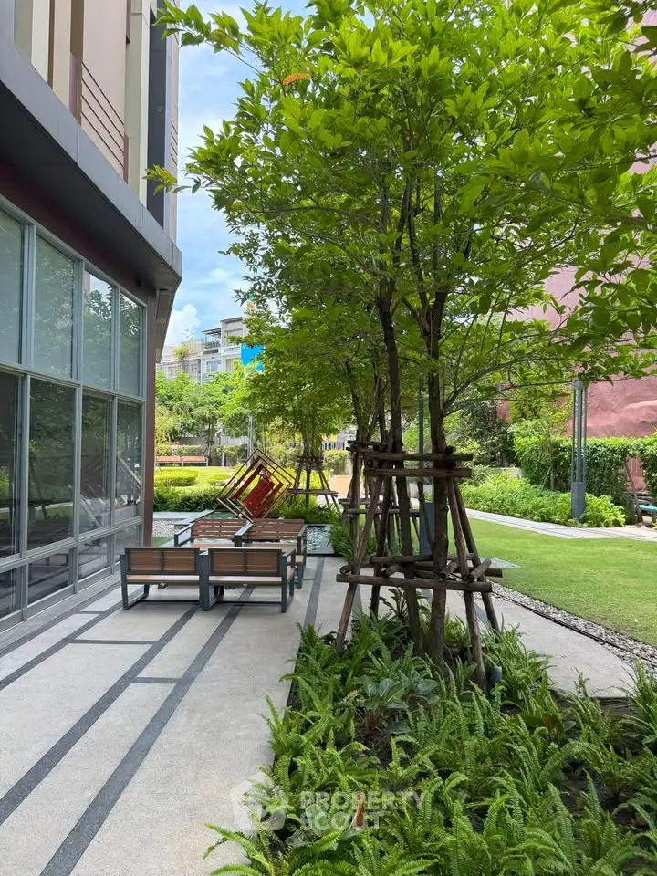 Modern building exterior with lush garden and outdoor seating area, perfect for relaxation and leisure.