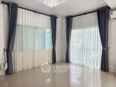 Spacious living room with elegant curtains and polished tile flooring