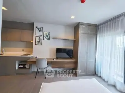 Modern bedroom with sleek furniture and natural light in a stylish apartment.