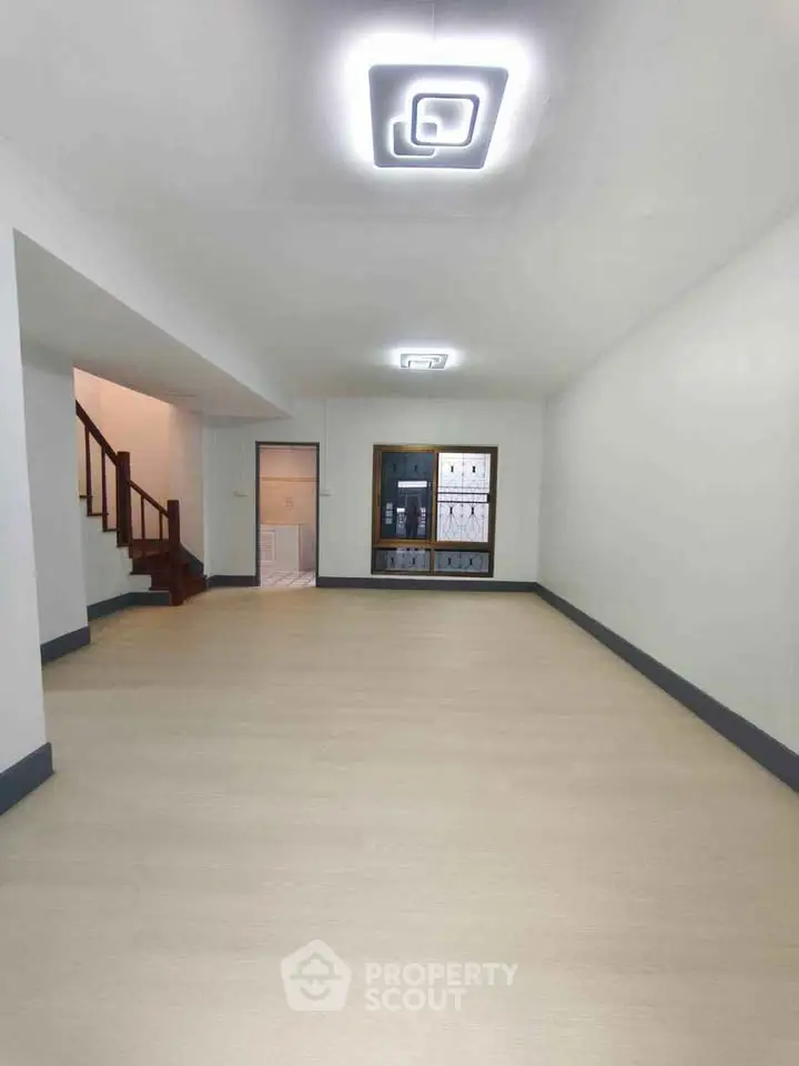 Spacious empty living room with modern lighting and staircase