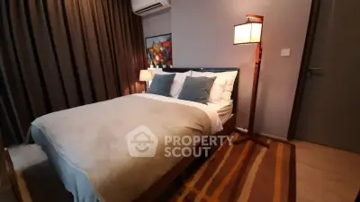 Cozy bedroom with modern decor and ambient lighting, featuring a comfortable bed and stylish floor lamp.