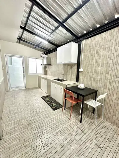 Modern kitchen with open layout and sleek design, featuring tiled walls and ceiling.