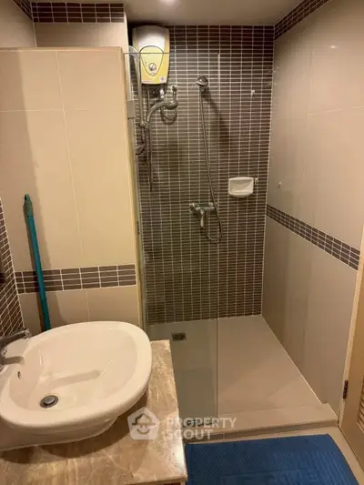 Modern bathroom with sleek shower and stylish sink in contemporary apartment.