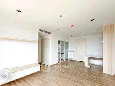 Spacious modern living room with wooden flooring and built-in shelves