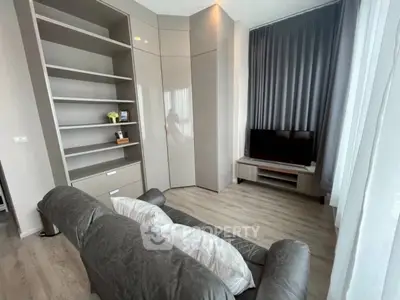 Modern living room with sleek shelving and cozy seating in a stylish apartment.