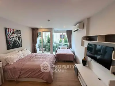Modern bedroom with balcony access, featuring stylish decor and ample natural light.
