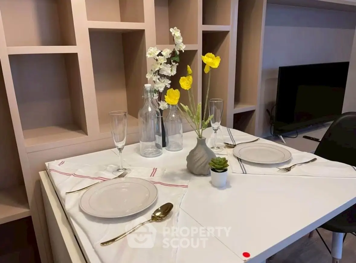 Elegant dining setup in modern living room with stylish shelving and TV unit.