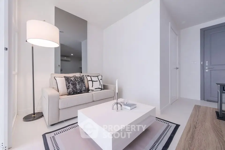 Modern living room with sleek white decor and cozy sofa in a stylish apartment.