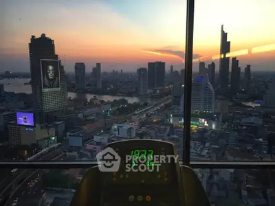 Stunning cityscape view from a high-rise gym with sunset backdrop.