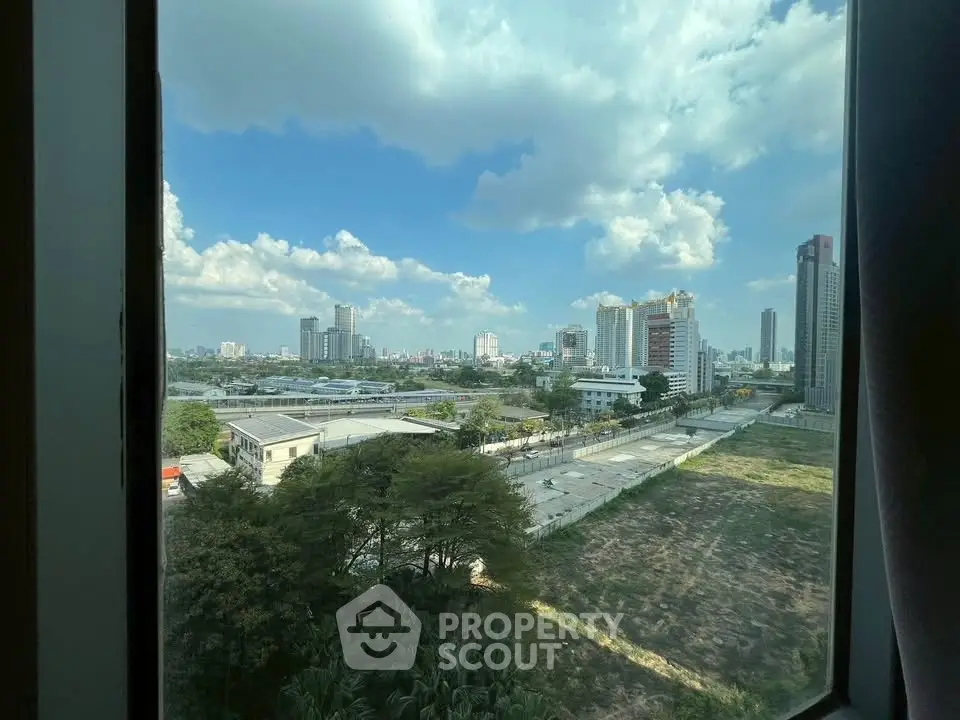 Stunning cityscape view from a high-rise window showcasing urban skyline and blue skies.