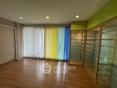 Spacious room with colorful blinds and built-in glass shelves, perfect for modern living.