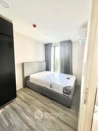 Modern bedroom with sleek design and large window for natural light.