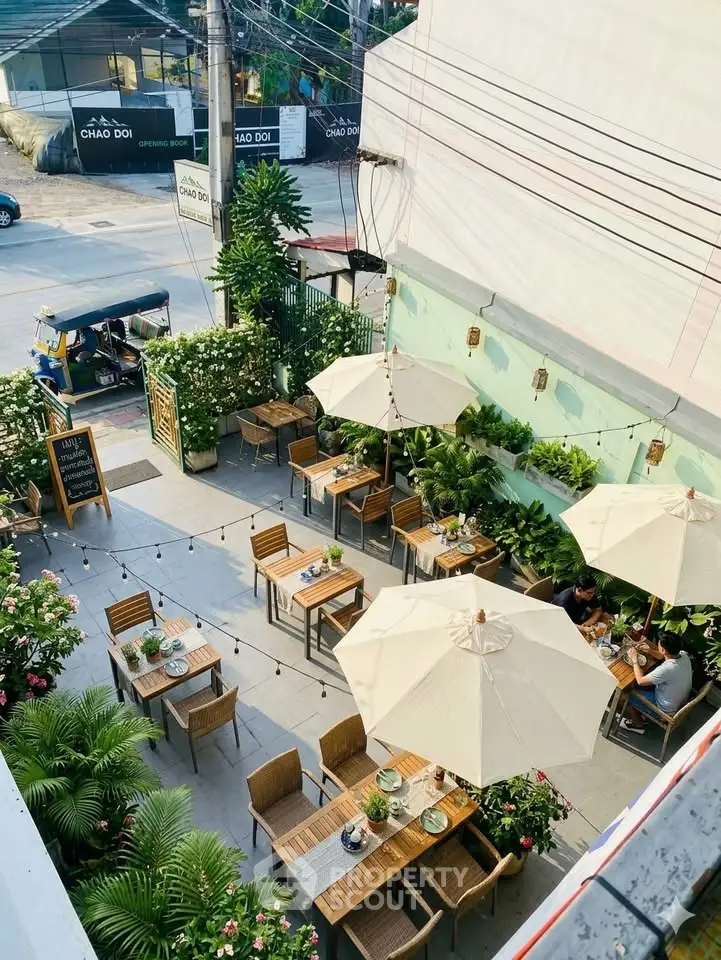 Charming outdoor dining area with elegant umbrellas and lush greenery, perfect for alfresco experiences.