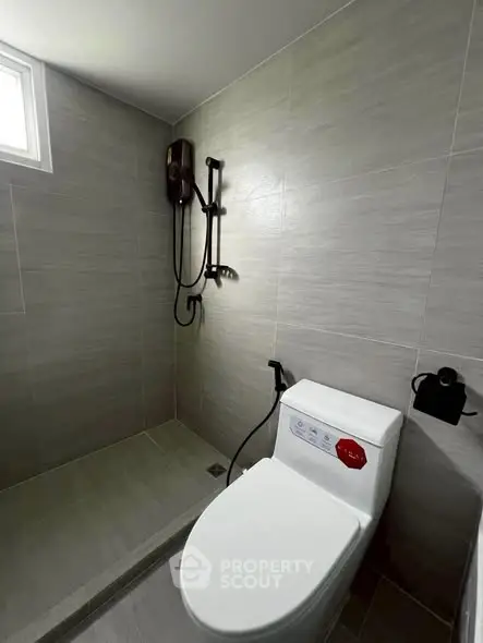 Modern bathroom with sleek shower and toilet in a minimalist design.