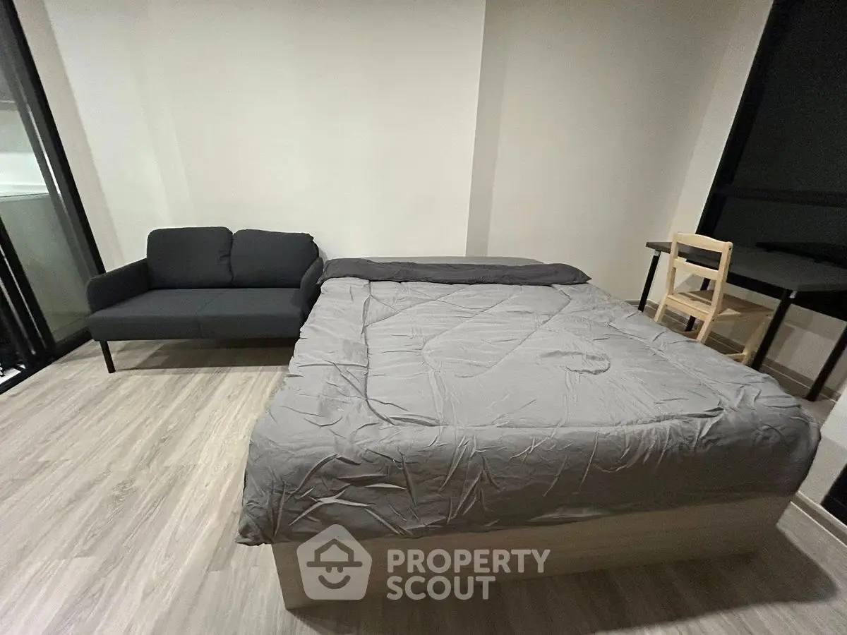 Modern bedroom with sleek design, featuring a cozy bed, stylish sofa, and minimalist decor.