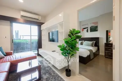 Modern living room with open view and adjacent bedroom, featuring sleek furniture and natural light.