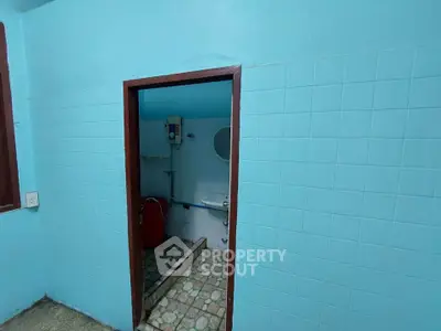 Compact bathroom with blue tiles and basic fixtures in a cozy home.