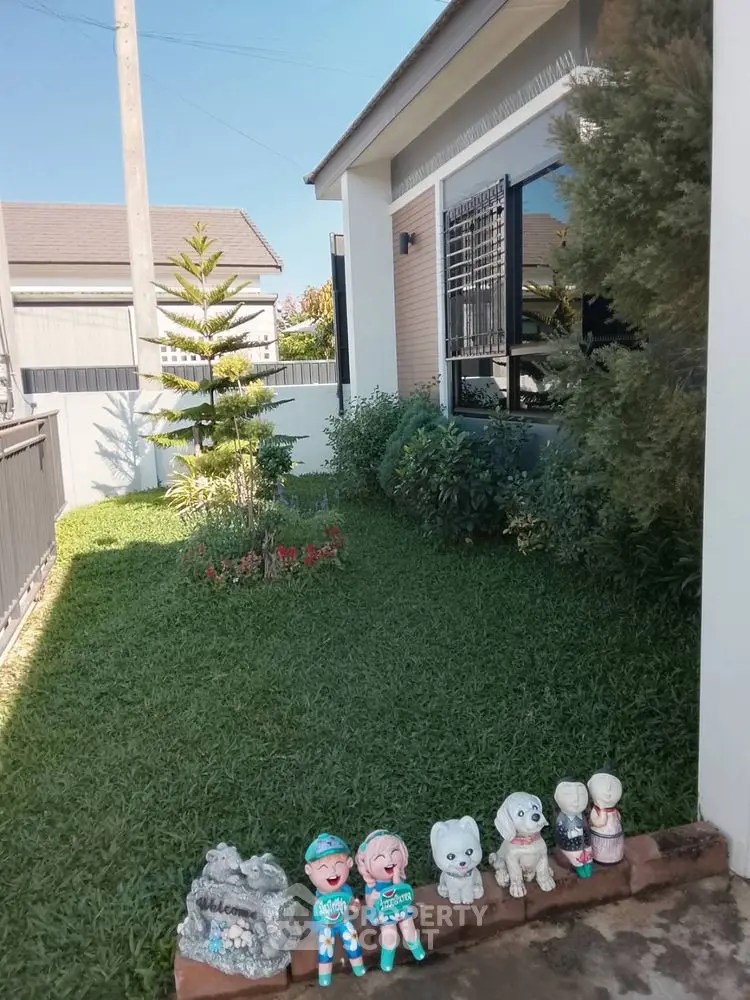 Charming garden view of suburban home with lush greenery and decorative statues.