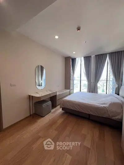 Spacious bedroom with large windows and elegant decor in modern apartment