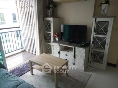 Charming living room with balcony access, featuring elegant cabinets and a cozy seating area.