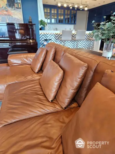 Luxurious leather sofa in modern living room with stylish kitchen backdrop