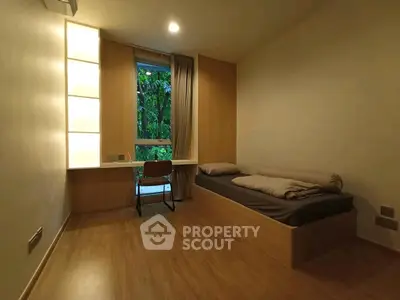 Cozy minimalist bedroom with wooden flooring and a serene garden view.