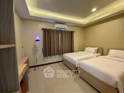 Spacious twin bedroom with modern lighting and cozy ambiance