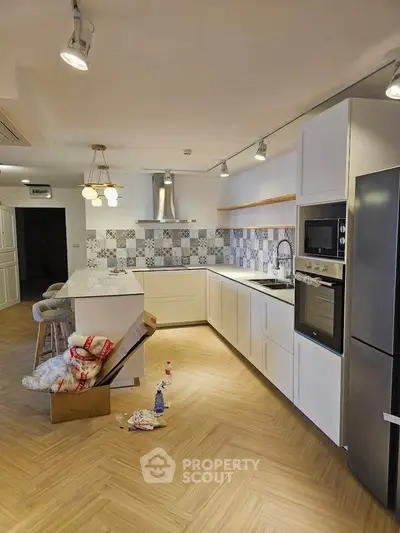 Modern kitchen with sleek appliances and stylish backsplash in open layout.
