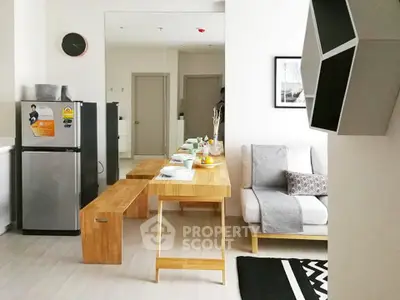Modern living room with sleek furniture and dining area, featuring a compact fridge and stylish decor.