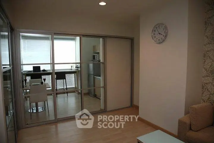 Modern apartment interior with mirrored sliding doors and cozy dining area.