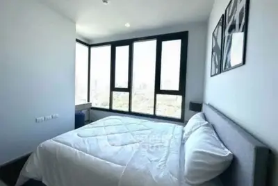 Modern bedroom with large windows offering stunning city views