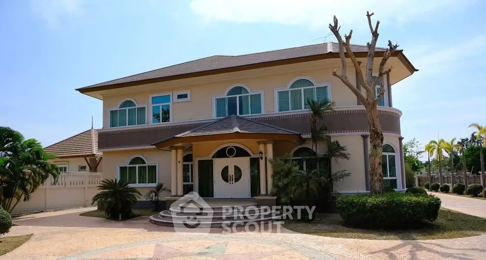 Stunning two-story house with elegant entrance and lush landscaping, perfect for luxurious living.